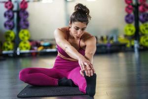 ung kvinna gör stretchövningar på en yogamatta foto