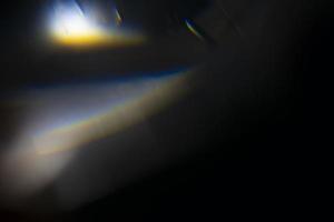 kristallljusläckageeffekt för fotoöverlagring. prisma lins flare bokeh abstrakt med glöd, färgglada och magiska ljus på svart bakgrund. foto