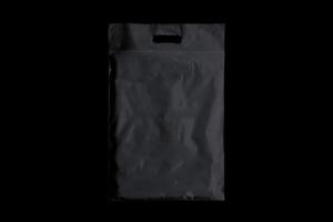 svart plastpåse isolerad på svart bakgrund för mockup design förhandsgranskning foto