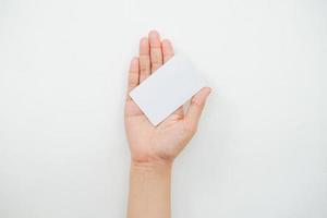 handen håller ett tomt vitt utrymme på en vit bakgrund. en kortmockup som är lämplig för affärs- eller identitetsmockupanvändning. foto