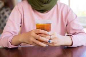 en dam njuter av sin drink på en traditionell vibbrestaurang. sommarvibbar i Indonesien. foto