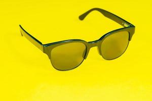 solglasögon på gul bakgrund. mode koncept foto