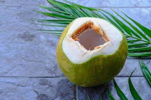 färsk grön kokosfrukt och kokosblad foto