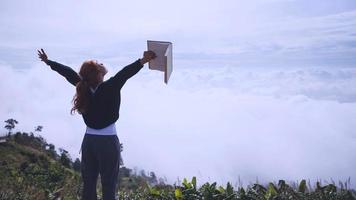 kvinnor koppla av läs morgonbok bra väder sky mist. på bergen, morgonstämningen. foto
