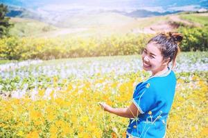 asiatiska kvinnor reser sömn slappna av. kvinnor hill stam i fältet av blommor cosmos sulphureus. thailand foto