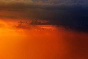 lysande orange solnedgång och soluppgång vacker över svarta moln med ljus orange sol på en sval vårmorgon. foto