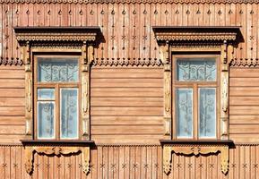 en del av träfasaden i det gamla stadshuset med snidade plattband, figurerade väggelement och metallgaller i fönstren. foto