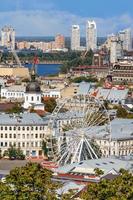 pariserhjul och klocktorn med koppartak och förgylld kupol i det gamla podildistriktet i Kiev, stadsbild en sommardag. foto