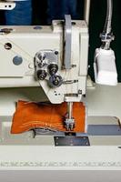 arbetsmekanismen för en industriell symaskin för tillverkning av möbelklädsel av läderimitation och andra täta tyger. foto