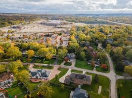 Flygfoto över bostadsområde i Northfield, il. massor av träd börjar få höstfärger. stora bostadshus, några med solpaneler. slingrande gator foto