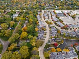 Flygfoto över bostadsområde i Northfield, il. massor av träd börjar få höstfärger. stora bostadslägenhetskomplex. slingrande gator med stora träd. foto