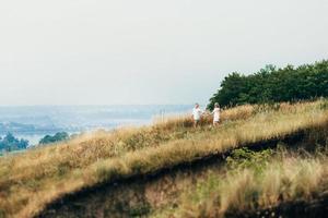 en kille med en tjej i ljusa kläder i bakgrunden av en grön kanjon foto