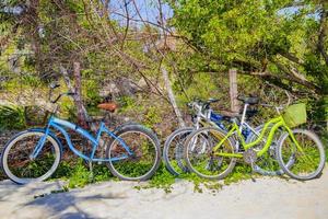 färgglada parkerade cyklar cyklar på stranden playa del carmen mexico. foto