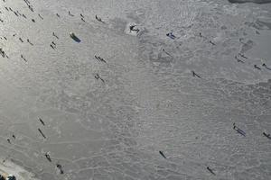 Flygfoto över bukten i isen med fiskare på vinterfiske. foto