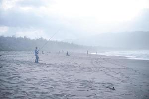 pacitan, indonesien 2021 - man som fiskar vid kusten foto