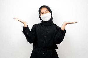 muslimsk kvinna som ler självsäkert med öppna handflator, presenterar något, presenterar produkt, isolerad på vit bakgrund