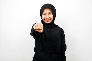 vacker ung asiatisk muslimsk kvinna som ler självsäker, entusiastisk och glad med knytnävar knutna mot kameran, slag, slåss, samarbete, glittrande ögon, tittar på kameran isolerad foto
