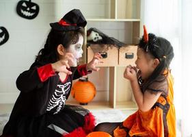 porträtt av två systrar i halloween kostym som beter sig som ett spöke skrämmande uttryck för varandra i halloween festival foto