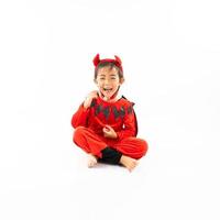 porträtt asiatisk liten söt flicka i ond kostym för halloween festival med pumpa foto