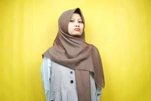 vacker ung asiatisk muslimsk kvinna upprörd, arg, missnöjd, missnöjd, hatisk, tittar på kameran isolerad på gul bakgrund