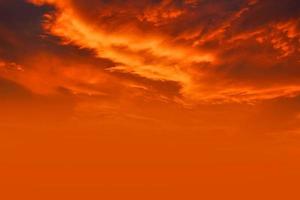 solnedgång och orange moln och blå gryningshimlen med moln horisontella linjer rörelseeffekt på bakgrund från solsken. foto