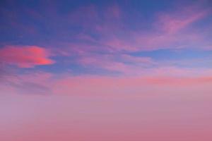 solnedgång och orange moln och blå gryningshimlen med moln horisontella linjer rörelseeffekt på bakgrund från solsken. foto