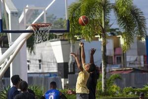 sorong, västra papua, indonesien, 28 november 2021. aktiviteterna på stadens torg på söndag morgon. människor som spelar basket foto