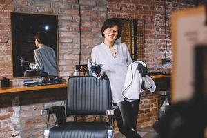 ung vacker frisör kvinna med sax i handen i barbashop salongen foto