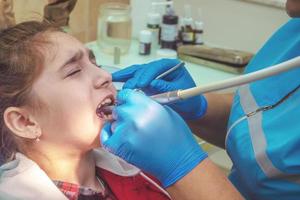 tonåring flicka på en mottagning på kontoret hos tandläkaren sitter i en stol. tandvård, smärta, rädsla foto
