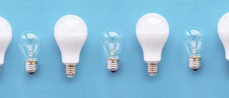 energisnåla lampor med glödlampor i rad på blå bakgrund. konceptet att spara energi.