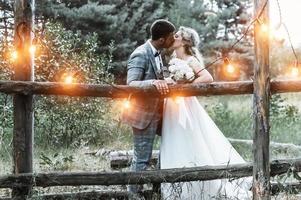 brudparet kysser i skogen vid bröllopsceremonin. selektiv fokusering. filmkorn. foto