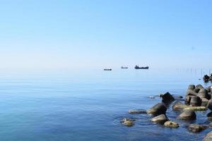 havsutsikt från stranden med strandvallar som skyddar kusten och havet. mjukt blått lugnt vatten med smärre krusningar. avkopplande havslandskap. kristallklart vatten i Svarta havet i Balchik, Bulgarien. foto