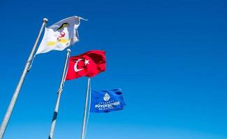 Turkiet flagga på stolpen med blå himmel bakgrund foto