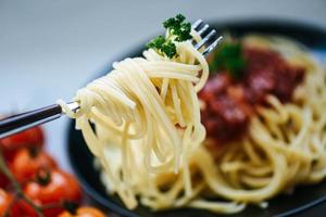 spagetti på gaffel och spagetti bolognese italiensk pasta med persilja i restaurangen italiensk mat och meny foto
