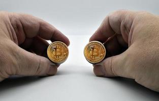 händerna på kaukasisk man som håller gyllene bitcoin-pengar isolerad på vit bakgrund foto