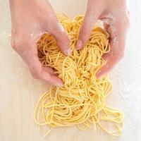 hemgjord italiensk pasta med kvinnans händer foto