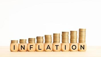 inflation koncept. text på träklossar och staplade mynt. kopieringsutrymme foto