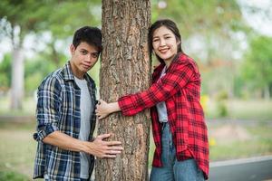 män och kvinnor som står och kramar träd. foto