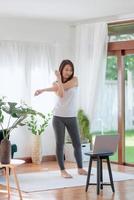 vacker asiatisk kvinna som håller sig i form genom att träna hemma för en hälsosam trendlivsstil