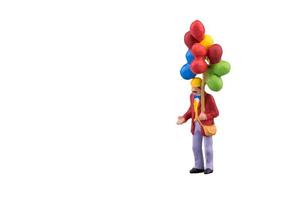 närbild av miniatyr människor med flytande ballong isolerad med urklippsbana på vit bakgrund. elegant design med kopieringsutrymme för placering av din text och mock up. foto