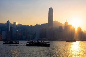 hong kong traditionell kinesisk träbåt för turistservice i victoria hamn vid solnedgången utsikt från kowloon-sidan i hong kong. foto