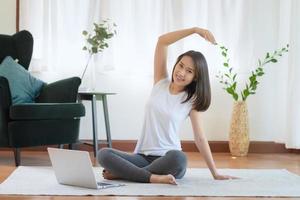 vacker asiatisk kvinna som håller sig i form genom att träna hemma för en hälsosam trendlivsstil