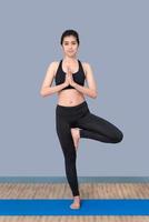 asiatisk kvinna behåller sig lugn och mediterar medan hon utövar yoga för att utforska den inre friden. yoga och meditation har goda fördelar för hälsan. fotokoncept för sport och hälsosam livsstil. foto