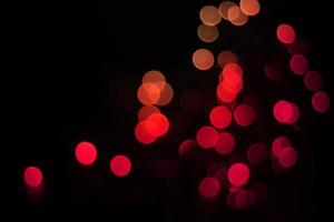 röd och orange oskärpa jul svart bakgrund. abstrakt svart ofokuserad oskärpa ljusa prickar svart. foto