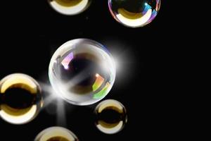 transparent färgglada bubblor tvål mönster överlägg abstrakta partiklar stänk av vatten på svart. foto