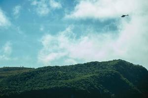 Helikopter som flyger över fortaleza-kanjonen med klippor täckta av tjock skog i en molnig dag nära cambara do sul. en liten lantstad i södra Brasilien med fantastiska naturliga turistattraktioner. foto