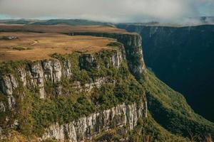 fortaleza kanjon formad av branta steniga klippor med skog och platt platå täckt av torra buskar nära cambara do sul. en liten lantstad i södra Brasilien med fantastiska naturliga turistattraktioner. foto