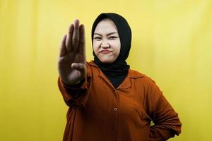 vacker asiatisk ung muslimsk kvinna med stoppskylt hand, avvisa tecken hand, förbudsskylt hand, närma dig inte, håll dig borta, isolerad foto