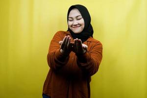 vacker ung asiatisk muslimsk kvinna ber, med öppna armar, isolerad foto