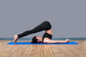 ung asiatisk kvinna tycker om att utöva yogaställning på yoga hälsosamt sportgym, yoga och meditation har goda fördelar för hälsan. fotokoncept för yogasport och hälsosam livsstil foto